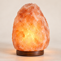 Original AI-generated mockup of a glowing pink salt lamp on a wood base